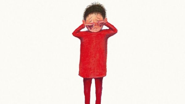 Ένα παιδί με κόκκινα ρούχα κλαίει